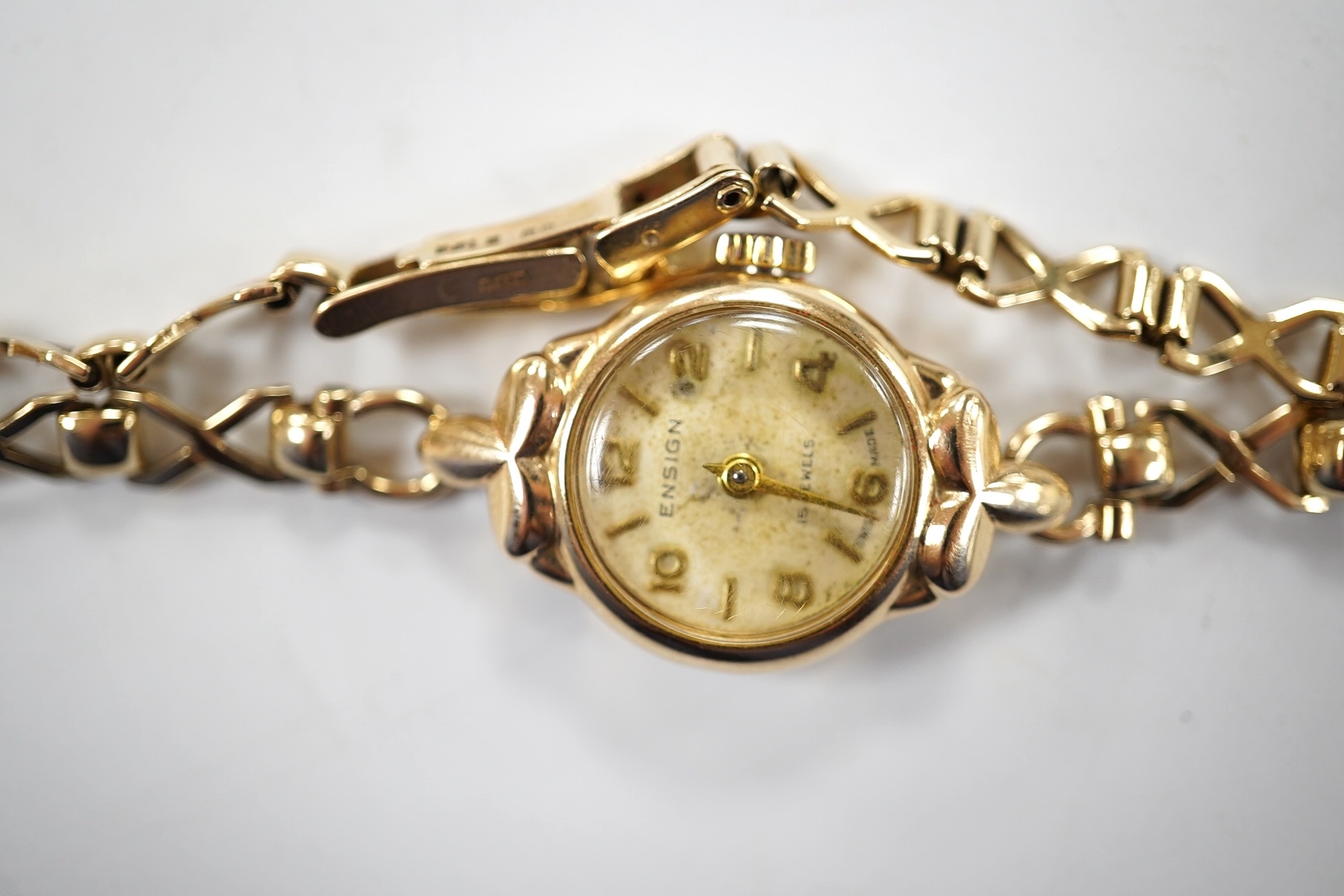 A lady's 9ct gold Ensign manual wind wrist watch, on a 9ct gold strap, gross weight 11.4 grams. Condition - fair